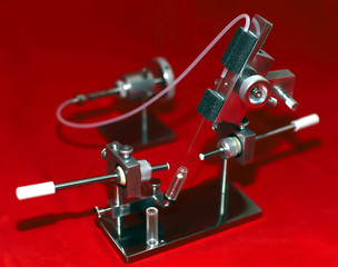tool for artificial insemination of queen bees on red background. Breeding thoroughbred bees....
