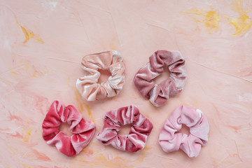 Collection of trendy velvet scrunchies on pink background. Diy accessories and hairstyles concept, copy space