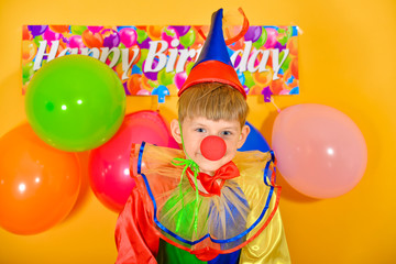 Child clown with balloons at a children's birthday party.