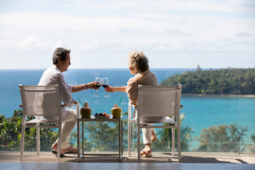 Happy senior Chinese couple relaxing on balcony