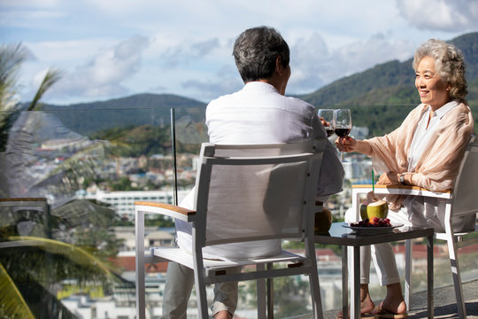 Happy senior Chinese couple relaxing on balcony - Powered by Adobe