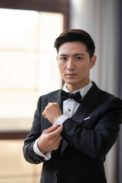 Young Chinese man getting dressed at home