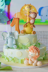 Obraz na płótnie Canvas Closeup first birthday celebration cake. Cute jungle animals cake decoration with number one candle.