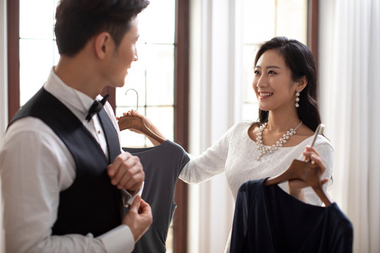 Happy young Chinese woman asking husband what to wear