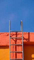 Fototapeta premium orange walls with stairs under the blue 