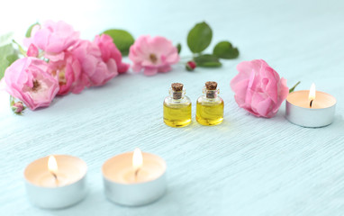 Fototapeta na wymiar Rosehip cosmetic oil in mini bottles and pink rosehip flowers. Spa treatments for relaxation.