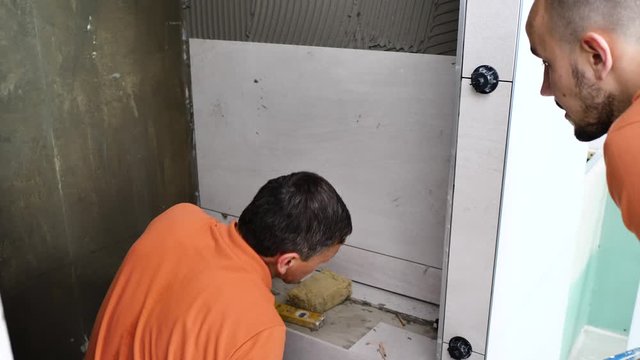  Fliesenleger bei der Arbeit, Renovierung eines Badezimmers 4k Video in zeitlupe