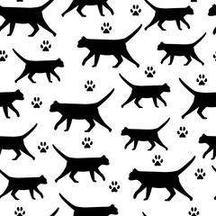 Vector seamless pattern of black cats and paw prints.