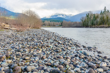 landscape with mountains trees and a river in front