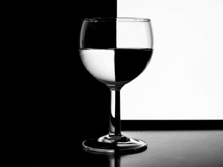 Ein Weinglas mit Wein vor einem schwarzweissen Hintergrund