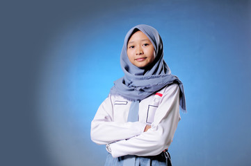 a Muslim high school student shows an expression of confidence blue background