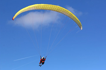 Tandem Paraglider flying wing in a blue sky	