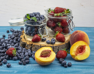 Fresh fruits. Healthy food. Mixed fruit, strawberries and blueberries, peaches. Studio photography of various fruits on an old wooden table. Organic healthy assorted fruits. Assortment of fresh fruit.