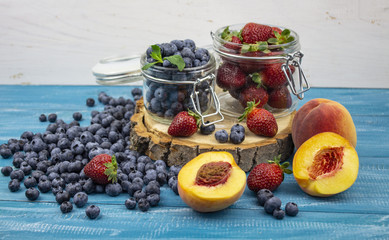 Fresh fruits. Healthy food. Mixed fruit, strawberries and blueberries, peaches. Studio photography of various fruits on an old wooden table. Organic healthy assorted fruits. Assortment of fresh fruit.