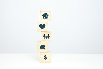 Insurance symbols on wooden blocks. Insurance and security concept. Health, life and valuable items insurance. Securing the family.