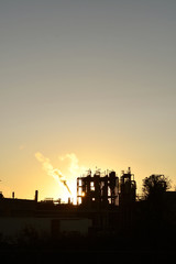 a factory with steam at sunset