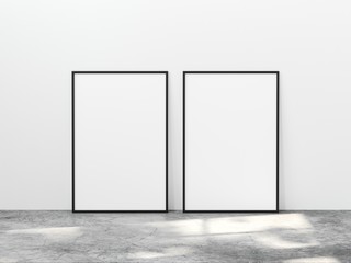 Two vertical black frame mock up on concrete floor with light overlays. Set of two black frame mock up poster 3d illustration.