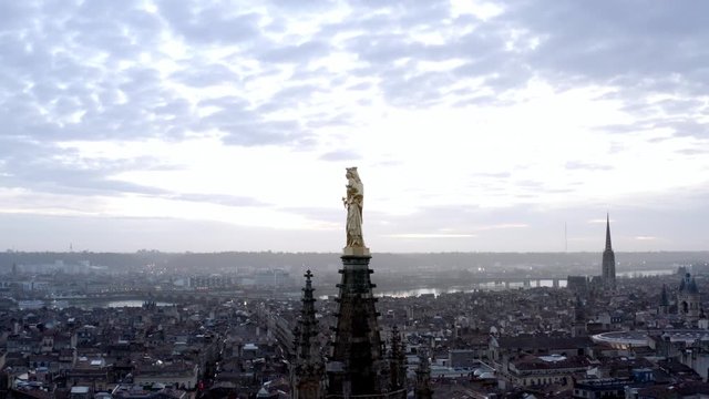 Madonna and child gold statue on Pey Berland bell tower St. Andrew Cathedral, Bordeaux France, Aerial drone pedestal lift shot