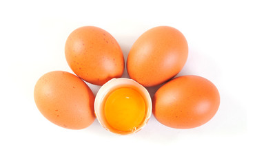 Top view of eggs with one broken on white background