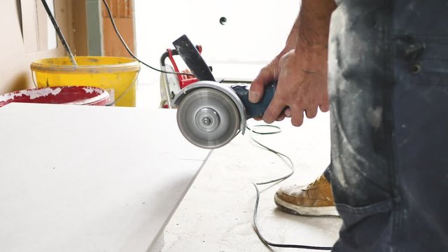 Fliesenleger schneidet fliesen mit einem winkelschleifer (flex) 4k video in zeilupe