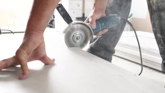 Fliesenleger schneidet fliesen mit einem winkelschleifer (flex) 4k video in zeilupe