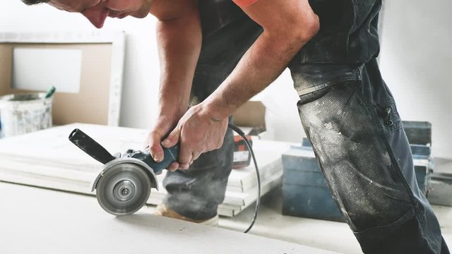 Fliesenleger schneidet fliesen mit einem winkelschleifer (flex) 4k video in zeilupe