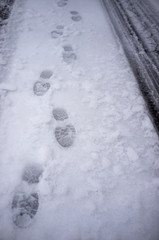 footsteps and car tracks in snow and ice in winter