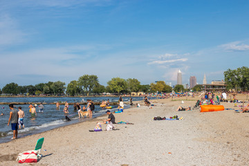 Lake Erie, Cltveland, Ohio/ USA - 3 September 2018: People relax on the beach, tall skyscrapers are visible in the distance. People celebrate Labor Day at Lake Erie in Cleveland.