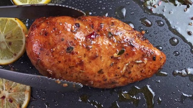 fried chicken steak fillet is overturned on the frying surface of the pan. slow motion