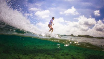 Surfer girl riding a wave over a coral reef, tropical lifestyle.
