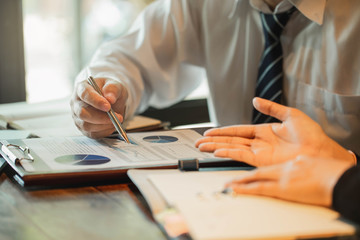 Business team brainstorming. Marketing plan researching. Paperwork on the table, laptop and mobile phone.Group business man and business women meetings to brainstorm, analyze and plan for marketing.