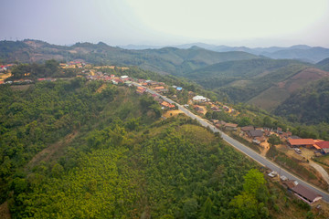 aerial scenic view of mountain road and rural village living along, in Laos. 