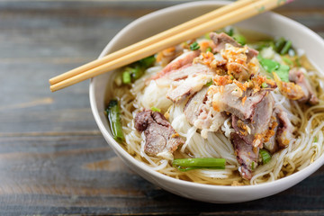 Rice noodles soup with beef in a bowl and chopsticks, Asian food