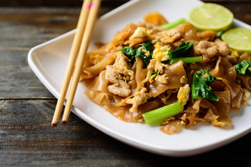 Stir-fried soy sauce rice noodles with pork and chopsticks, Thai food (Pad See Ew)