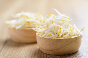 Fresh mung bean sprouts in a bowl on wooden background