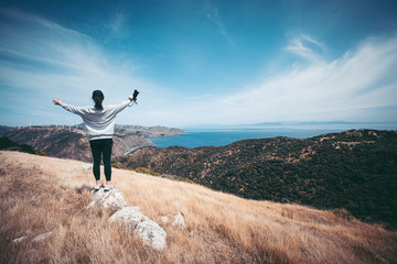 Obraz premium Woman photographer hiking on Makara beach, Wellington, NZ