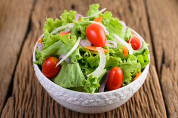 Salad on the bowl on wooden table.