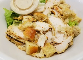 Grilled chicken caesar salad inside a white bowl
