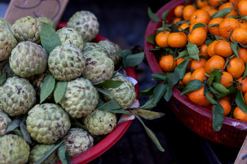 sugar apple and tangerine are in baskets in the Asian market