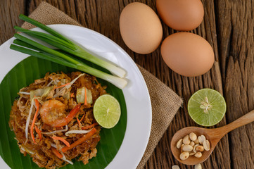 Obraz na płótnie Canvas Padthai shrimp in a black bowl with eggs, Spring onion, and Seasoning on wooden table.