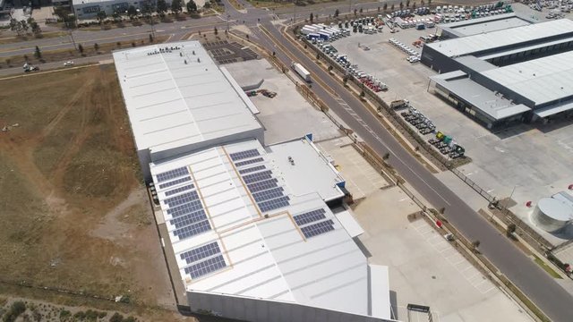 Solar panels installed on roof of industrial warehouse aerial