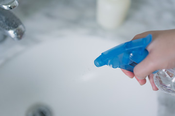 The sprayer with the disinfectant was cleaning the faucet