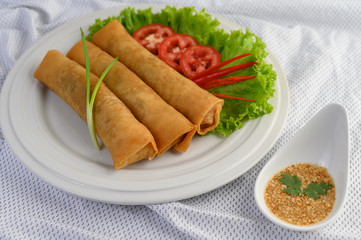 Egg roll or Fried Spring Rolls on the white plate Thai food. Selective focus.
