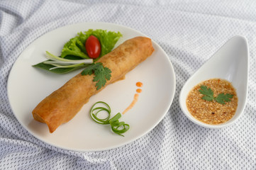 Egg roll or Fried Spring Rolls on the white plate Thai food. Selective focus.