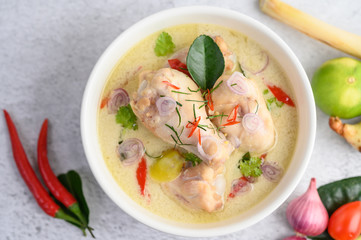 Tom Kha Kai in a bowl with kaffir lime leaves, lemongrass, red onion, galangal and chilli.