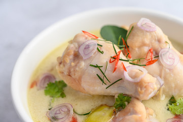 Tom Kha Kai in a bowl with kaffir lime leaves, lemongrass, red onion, galangal and chilli.