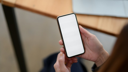 Close up view of a woman using blank screen smartphone