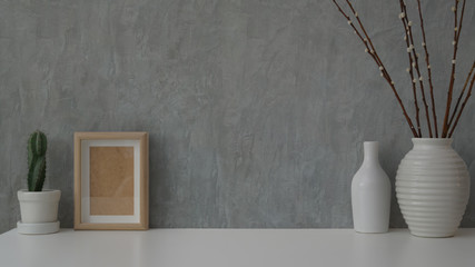 Close up view of minimal workspace on white table with grey loft wall