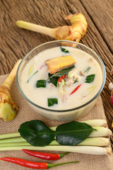 Tom Kha Kai in a bowl with kaffir lime leaves, lemongrass, red onion, galangal and chilli.
