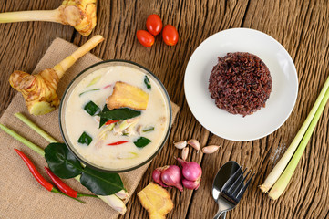 Tom Kha Kai in a bowl with kaffir lime leaves, lemongrass, red onion, galangal and chilli.